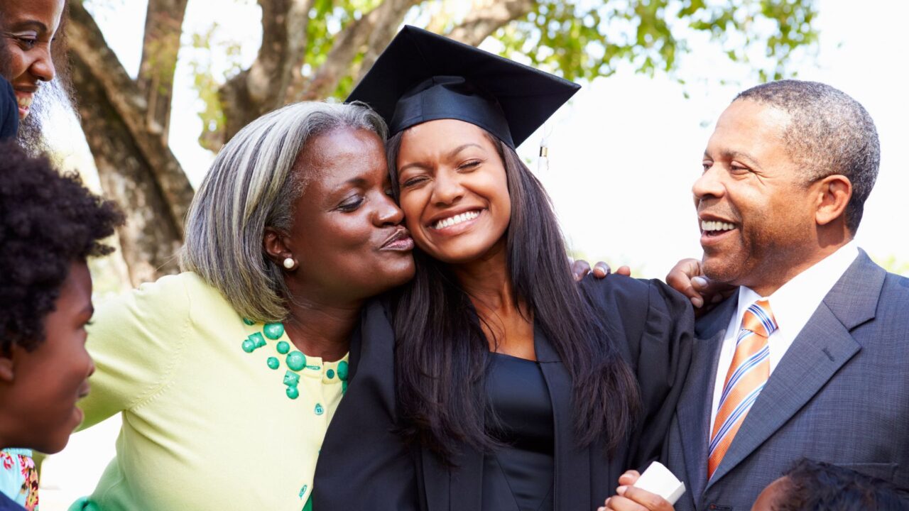 Family smiling with grad student in cap and gown