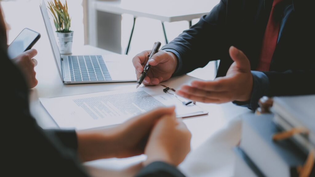 hand holding pen over papers