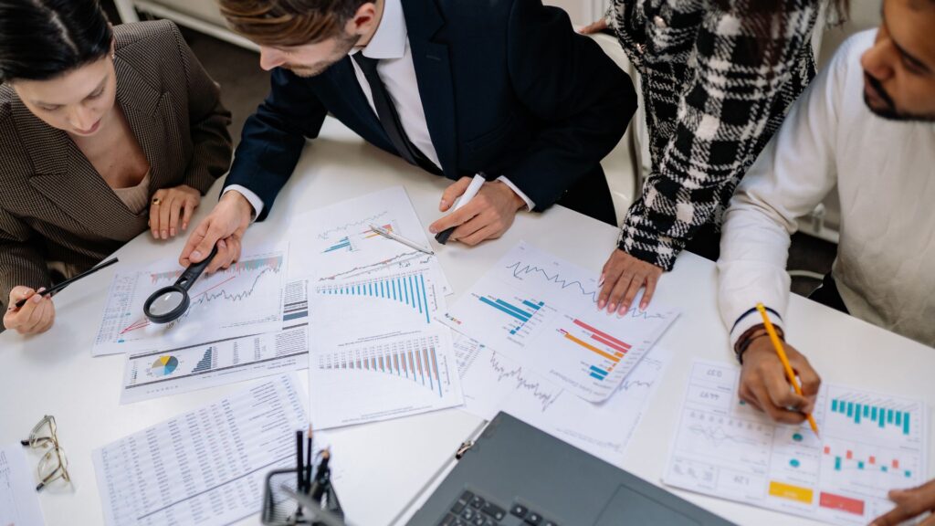 Executives huddled over a table full of papers