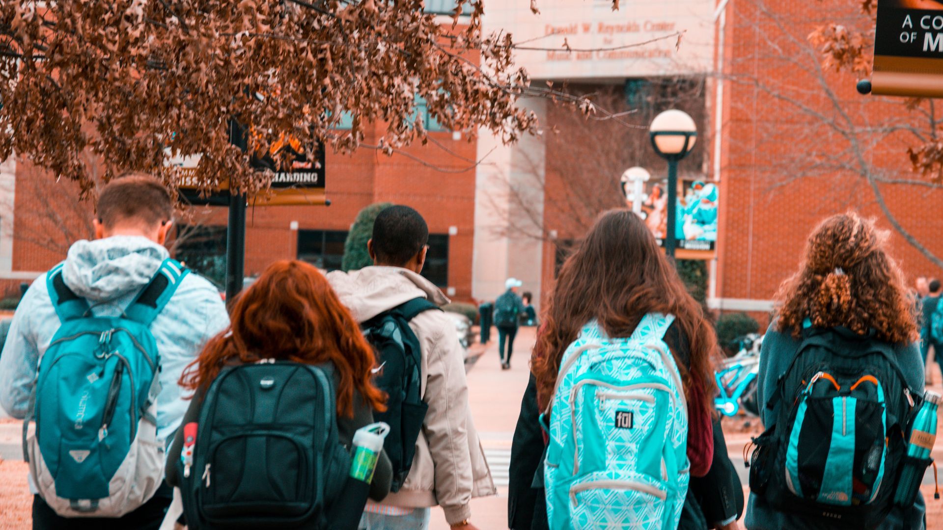 students with backpacks walking on campus