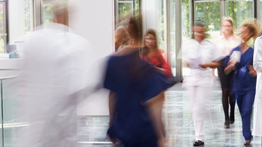 a blur of people walking in a healthcare setting