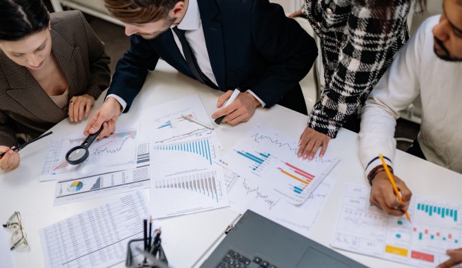 Executives huddled over a table full of papers