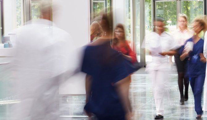a blur of people walking in a healthcare setting