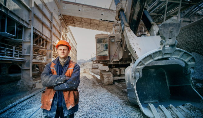 shutterstock_worker-in-a-helmet-stands-near-a-big-excavator-crossed-arms-162135476-1